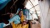 Ashia Saleh, from Barkatil village, holds her baby inside a make shift tent at the Kalma refugee camp for internally displaced people, south of the Darfur town of Nyala, Sudan, Mar. 9, 2014. (Credit: UNAMID)