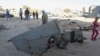 People stand next to the wreckage of a government MiG Libyan fighter jet that crashed during fighting Islamist fighters, in Benghazi, July 29, 2014.