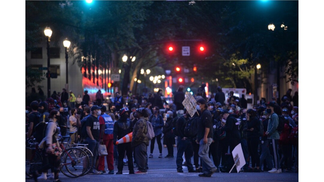 FILE - People protest in front of the Multnomah County Justice Center in Portland, Oregon, July 17, 2020.