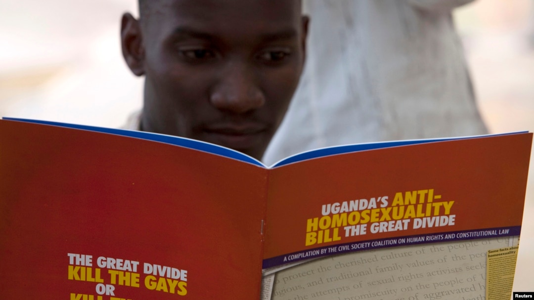 FILE - A man reads a publication by a civil society coalition on human rights and constitutional law in Kampala.