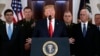 President Donald Trump addresses the nation from the White House on the ballistic missile strike that Iran launched against Iraqi air bases housing U.S. troops, Jan. 8, 2020, in Washington, as Vice President Mike Pence and others looks on.