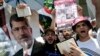 Supporters of ousted Egyptian President Mohmmed Morsi hold Islam's holy books Quran, as they chant slogans against Egyptian Defense Minister Gen. Abdel-Fattah el-Sissi outside the Engineers’ Syndicate during a press conference with Morsi's family, in Cair
