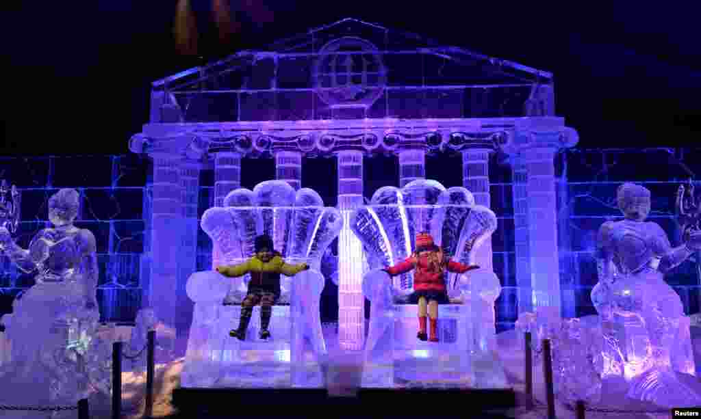 Jack Drury and Ruby Darragh sit on ice sculptures at the launch of Hyde Park Winter Wonderland&#39;s Magical Ice Kingdom in London.