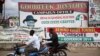 FILE - Men ride past motorcycles in front of a Peoples Democratic Party office at the Osun state governorship election in Osogbo, southwest Nigeria, Aug. 9, 2014.