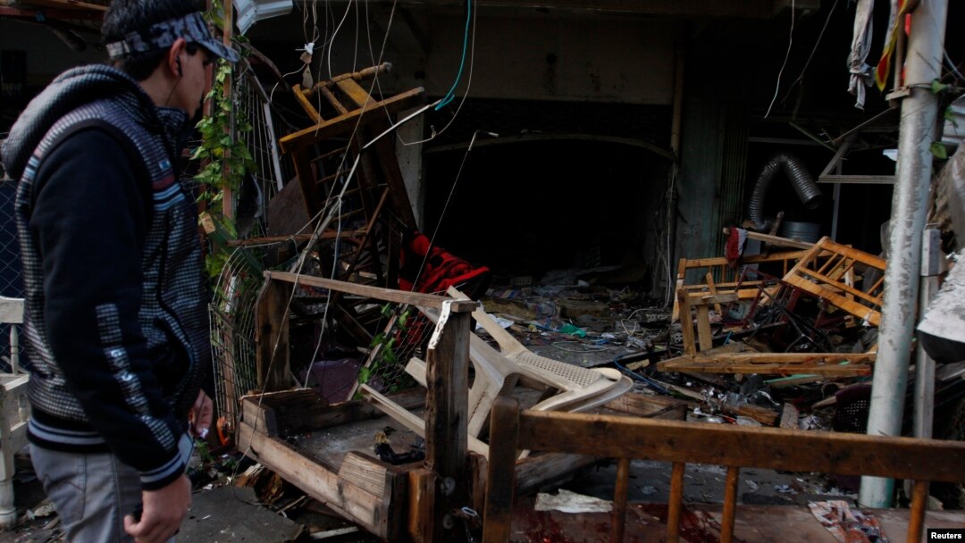 A man looks at the site of a bomb attack at a cafe in Baghdad's al-Bayaa district, Nov. 21, 2013. 