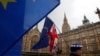 Anti Brexit demonstrators hold up their flags opposite the Houses of Parliament in London, April 3, 2019.