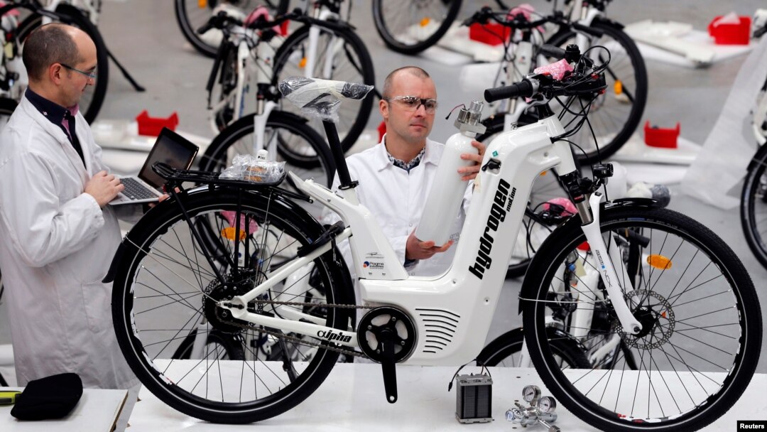 Pierre Forte (R), founder and CEO of Pragma Industries, and Alexandre Blanc (L), operations director, check an Alpha bike, first industrialized bicycle to use a hydrogen fuel cell at the Pragma Industries factory in Biarritz, France, Jan. 15, 2018. 