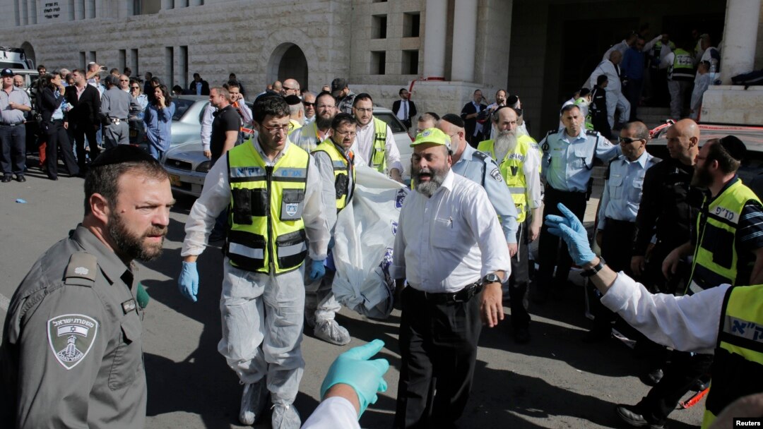 Israeli emergency personnel carry a covered body from the scene of an attack at a Jerusalem synagogue, Nov. 18, 2014. 