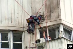 俄罗斯调查人员在检查一架乌克兰无人机对莫斯科一座公寓楼造成的损害。(2023年5月30日)