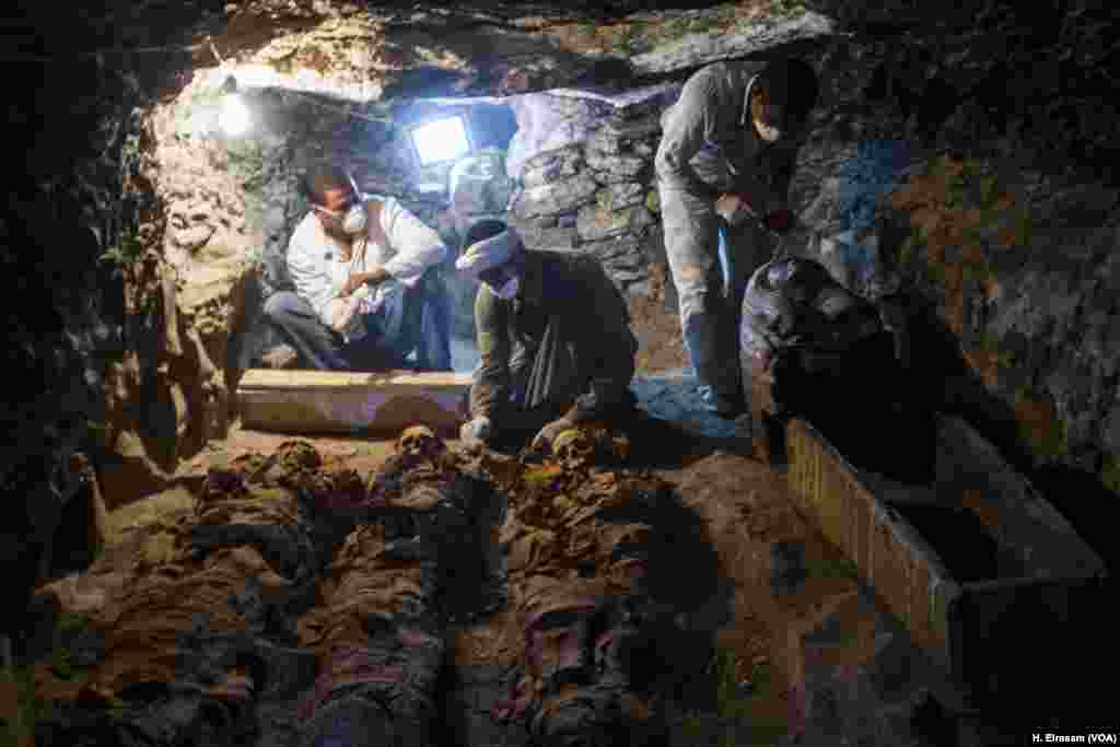 Egyptian archaeological workers restore mummies and a sarcophagi in the (KAMPP 390) tomb, in Luxor, Sept. 9, 2017.
