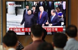 FILE - People watch a television news screen showing U.S. President Donald Trump, South Korean Moon Jae-in and North Korean leader Kim Jong Un meeting at the truce village of Panmunjom in the DMZ, at a railway station in Seoul, June 30, 2019.