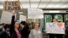 Lawyers offer free counseling as they join dozens of pro-immigration demonstrators cheering and holding signs as international passengers arrive at Dulles International Airport to protest President Donald Trump's travel ban in suburban Washington, Jan. 29