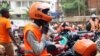 FILE - A motorcycle taxi driver known as boda-boda, from SafeBoda network, waits for a customer along a street in Kampala, Uganda, Oct. 5, 2018.