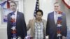 An Afghan man poses next to cutout figures of US presidential candidates, President Barack Obama, left, and Mitt Romney, for a snapshot during a U.S. election event at the U.S. Embassy in Kabul, Nov. 7, 2012. 