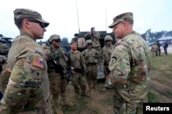 AQShning Yevropadagi qo'mondoni general-leytenant Ben Xodjes (chapdan) askarlar bilan gaplashmoqda, Polsha
