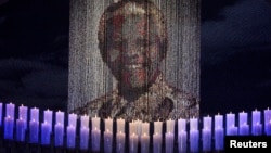 Candles are lit under a portrait of former South African President Nelson Mandela in his ancestral village of Qunu, Dec. 15, 2013.
