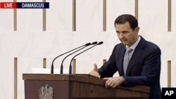 FILE - Syrian President Bashar al-Assad is seen delivering a speech in Damascus.