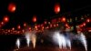 People watch fireworks to celebrate the start of the Chinese New Year in front of a restaurant in Beijing, Jan. 31, 2014.