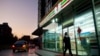 一名女子走過北京街頭一家7-Eleven便利店。（2012年1月3日）