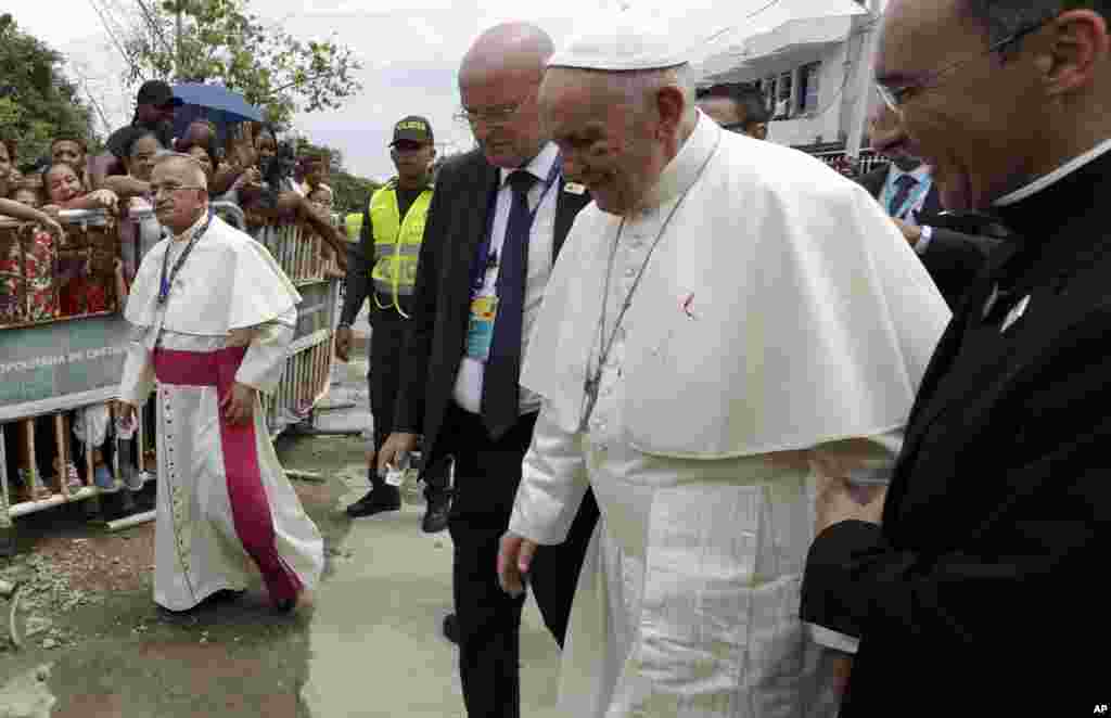 Small drops of blood stain Pope Francis' white cassock as he is helped by a priest after knocking his face on the popemobile in Cartagena, Colombia.