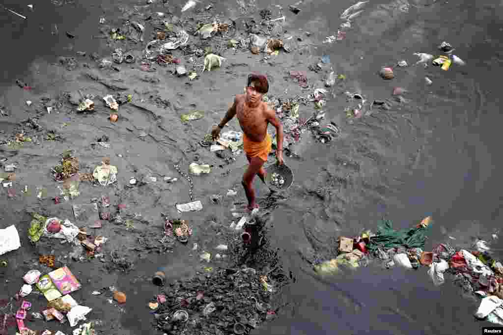 A man sifts through rubbish in the Yamuna river in Delhi, India.