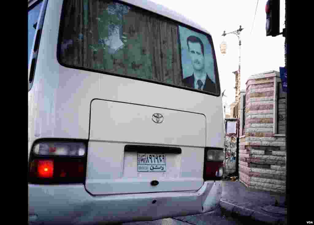 Avtobus oynalarida prezident Bashar al-Assadning suratini ko'rib qolasiz.