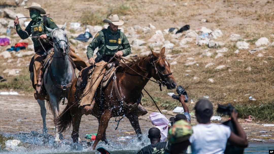 US Customs and Border Protection mounted officers attempt to contain migrants as they cross the Rio Grande from Ciudad Acuña, Mexico, into Del Rio, Texas, Sept. 19, 2021.