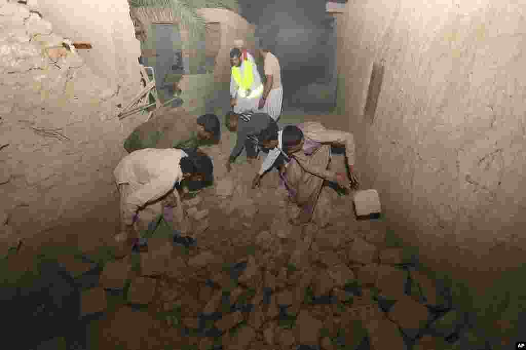 In this photo taken April 16, 2013, Iranians clear a route at the Gosht district after an earthquake hit southeastern Iran.