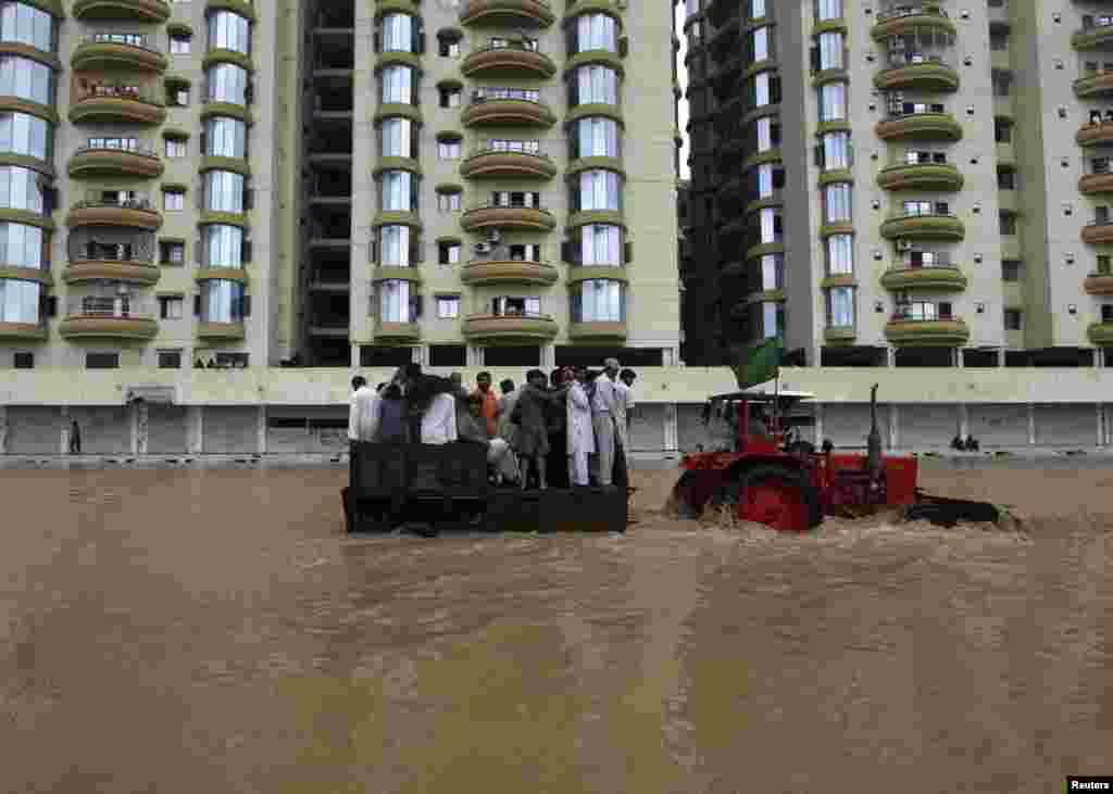 A tractor tows residents through flood waters to a safe place on the outskirts of Karachi, August 4, 2013. 