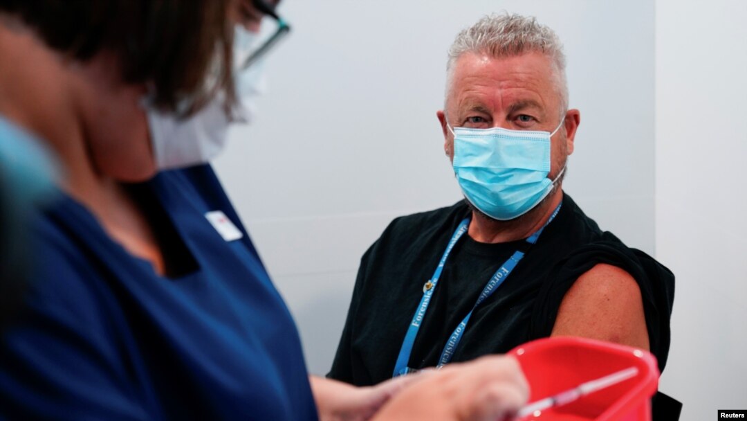FILE - A nurse prepares a dose of a COVID-19 vaccine for a physician, classified as high-risk, in Melbourne, Australia, Feb. 22, 2021.