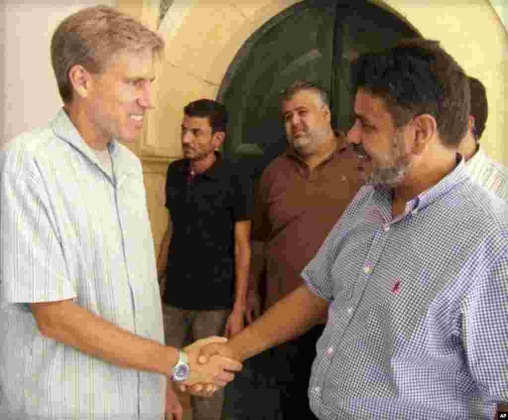 Elchi Kris Stivens liviyaliklar bilan qo'l berib ko'rishmoqda. Tripoli, 27-avgust, 2012-yil.