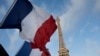 French flags fly as the closed Eiffel Tower is seen in the background on the first of three days of national mourning in Paris, Nov. 15, 2015. 