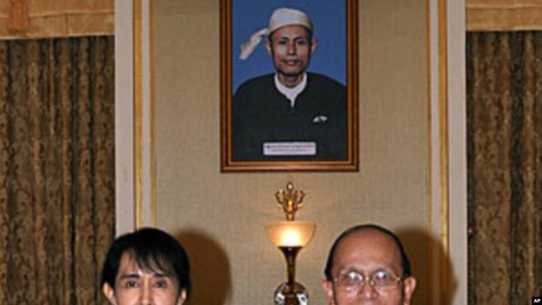 Burma's democracy icon Aung San Suu Kyi and President Thein Sein pose for photos before their meeting at the presidential office in Naypyitaw, August 19, 2011