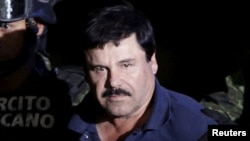 FILE - Recaptured drug lord Joaquin 'El Chapo' Guzman is escorted by soldiers at the hangar belonging to the office of the Attorney General in Mexico City, Mexico Jan. 8, 2016.