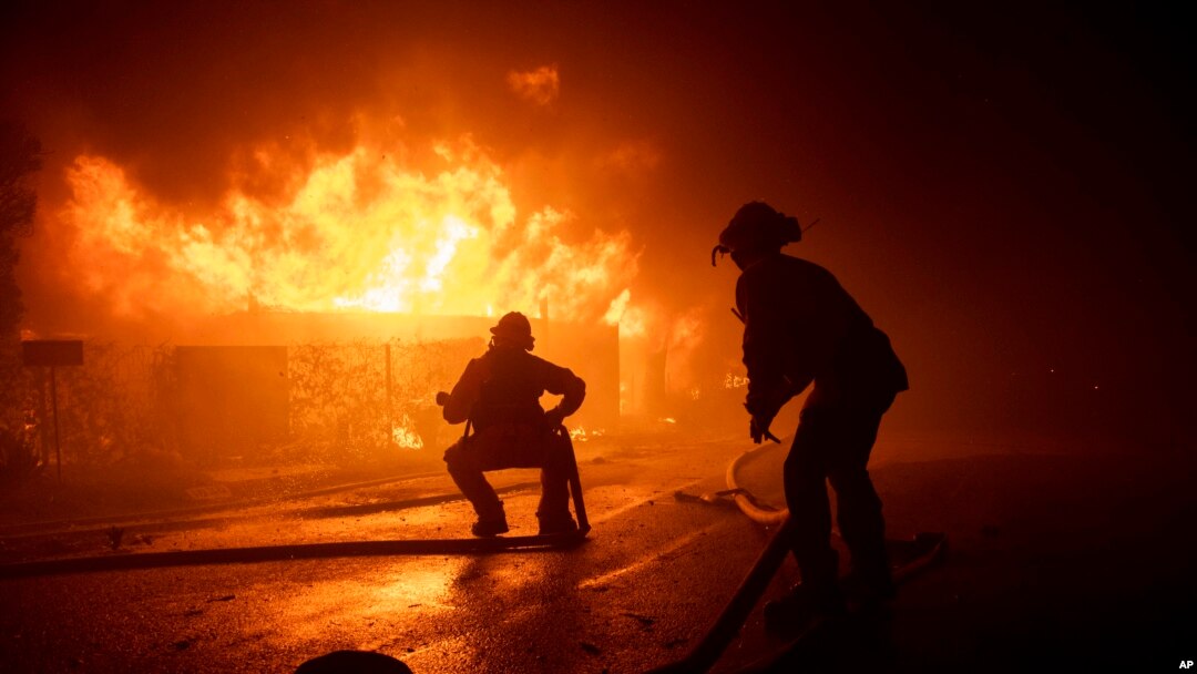 Firefighters try to save a home on Tigertail Road during the Getty fire, Monday, Oct. 28, 2019, in Los Angeles, Calif. (AP Photo/ Christian Monterrosa)