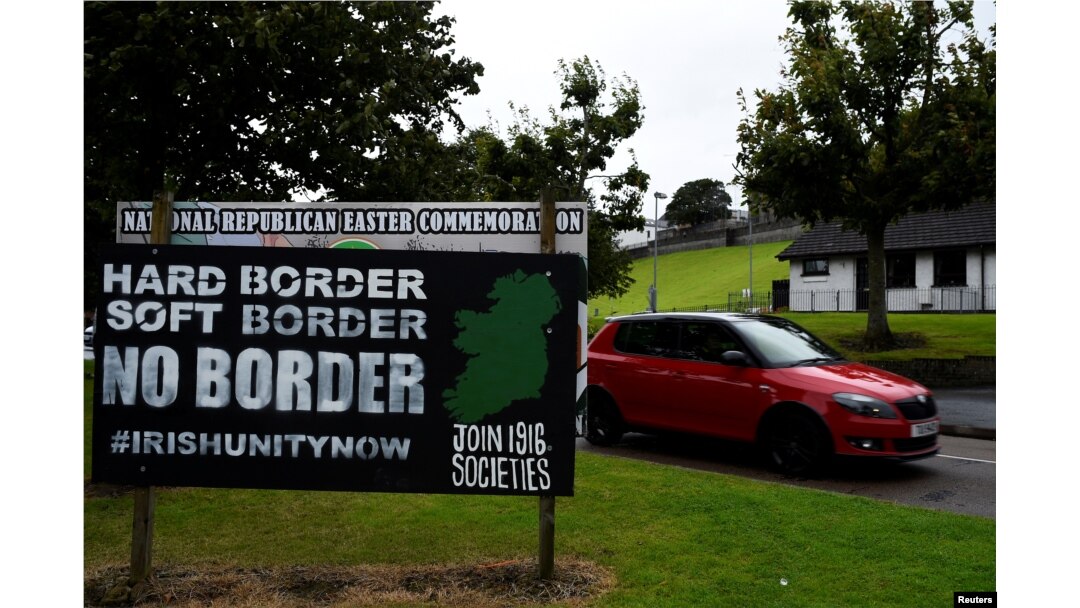 A car drives past a sign saying "No Border, Hard border, soft border, no border" in Londonderry, Northern Ireland, Aug. 16, 2017.