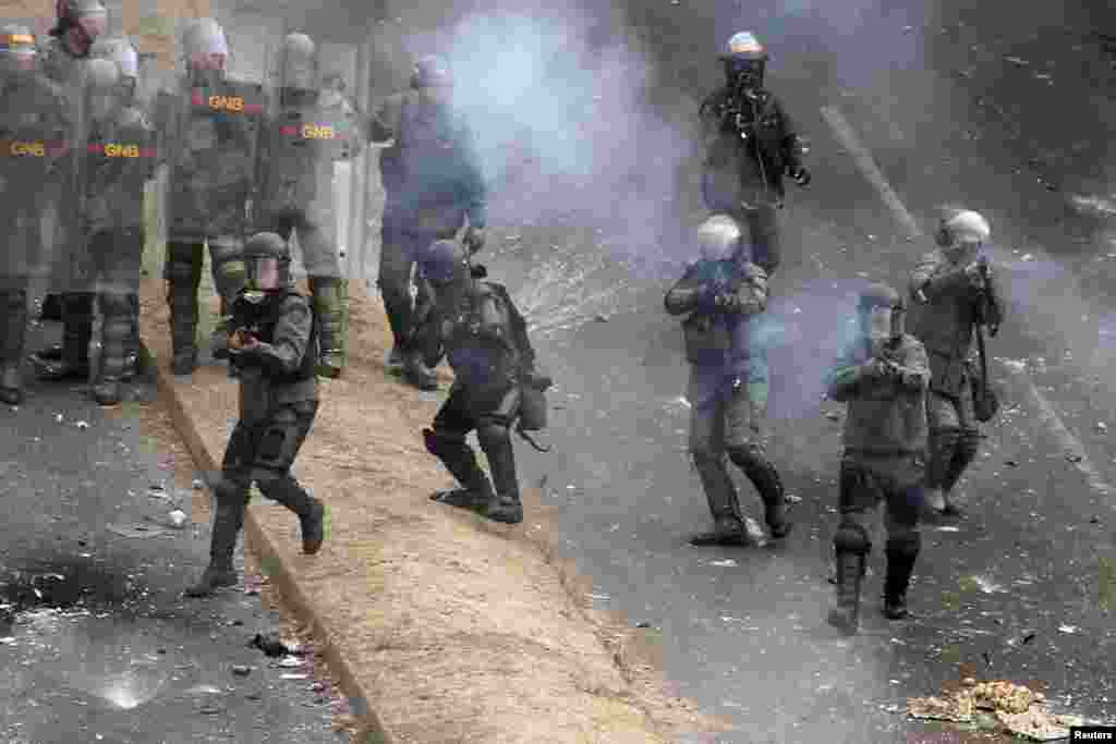 Tropas da Guarda Nacional disparam contra os manifestante durante o protesto contra o presidente venezuelano Nicolás Maduro em San Cristobal, Fev. 27, 2014.