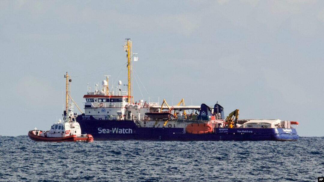 An Italian Coast Guard patrol boat flanks the Sea-Watch rescue ship off the Sicilian coast where it found shelter, about one nautical mile from Siracusa, from gale winds sweeping the Sicilian Channel, Jan. 25, 2019. 