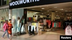 FILE - Shoppers walk into a Woolworths store at a shopping center in Lenasia, south of Johannesburg, August 2013.