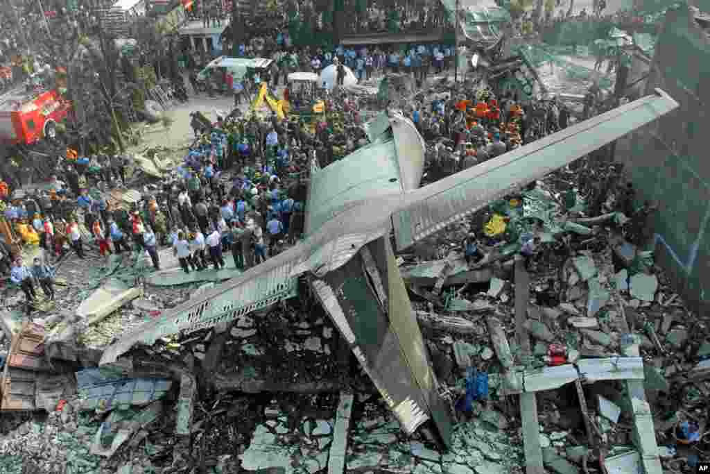Para petugas mencari korban di lokasi jatuhnya pesawat Hercules C-130B di Medan (30/6). (AP/Yudha Lesmana)