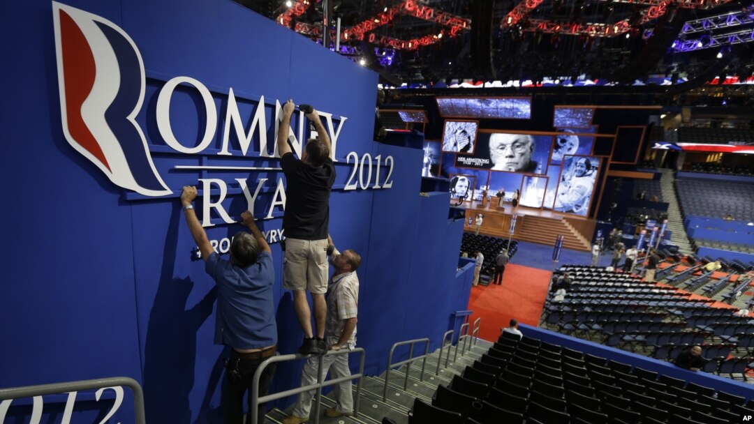 Workers place a Romney-Ryan campaign sign inside of the Tampa Bay Times Forum at the Republican National Convention in Tampa, Florida, Sunday, Aug. 26, 2012. 