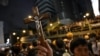FILE - A protester holds a Christian cross as others gather outside the police headquarters in Hong Kong, June 21, 2019.