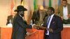 FILE - South Sudan's President Salva Kiir, left, and South Sudan's rebel commander Riek Machar exchange documents after signing a cease-fire agreement during an Inter Governmental Authority on Development (IGAD) Summit in Addis Ababa, Ethiopia.