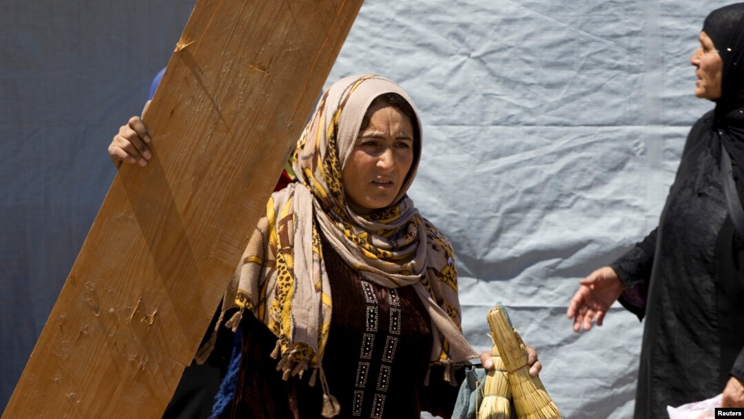 Syrian woman prepare to move their home at the request of the land owner at a refugee camp in the east Lebanese town of Anjar near the Syrian border, May 13, 2014. 