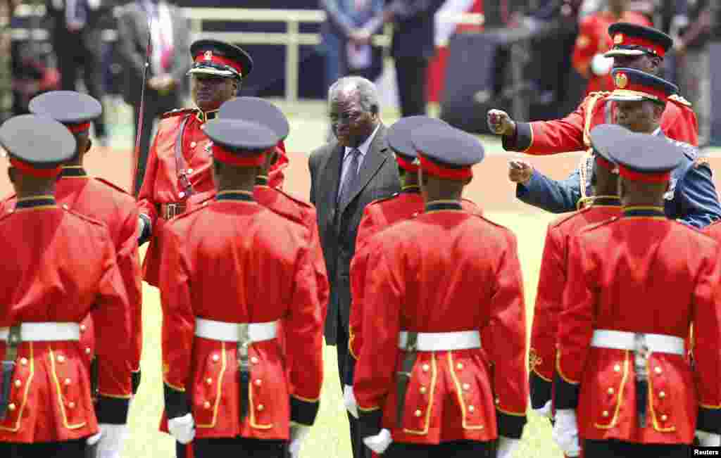 Kenya's outgoing President Mwai Kibaki inspects the honor guard before the official swearing-in ceremony of President Uhuru Kenyatta at Kasarani Stadium, Nairobi, April 9, 2013.