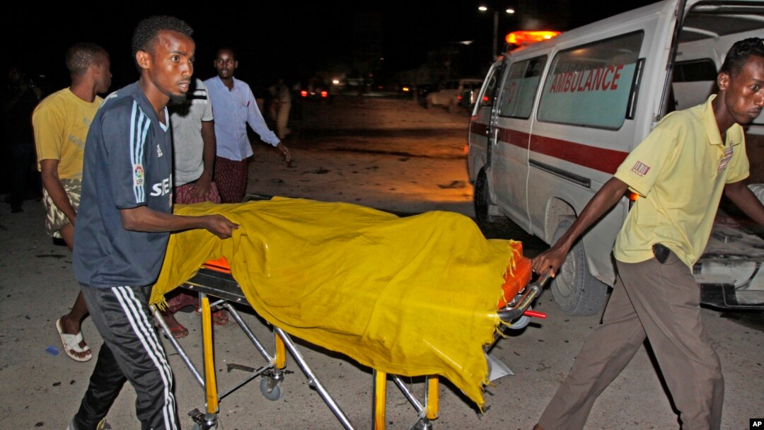 Rescuers remove a dead body from the scene of a car bomb attack close to the presidential palace in the capital Mogadishu, Somalia, Oct. 15, 2014.