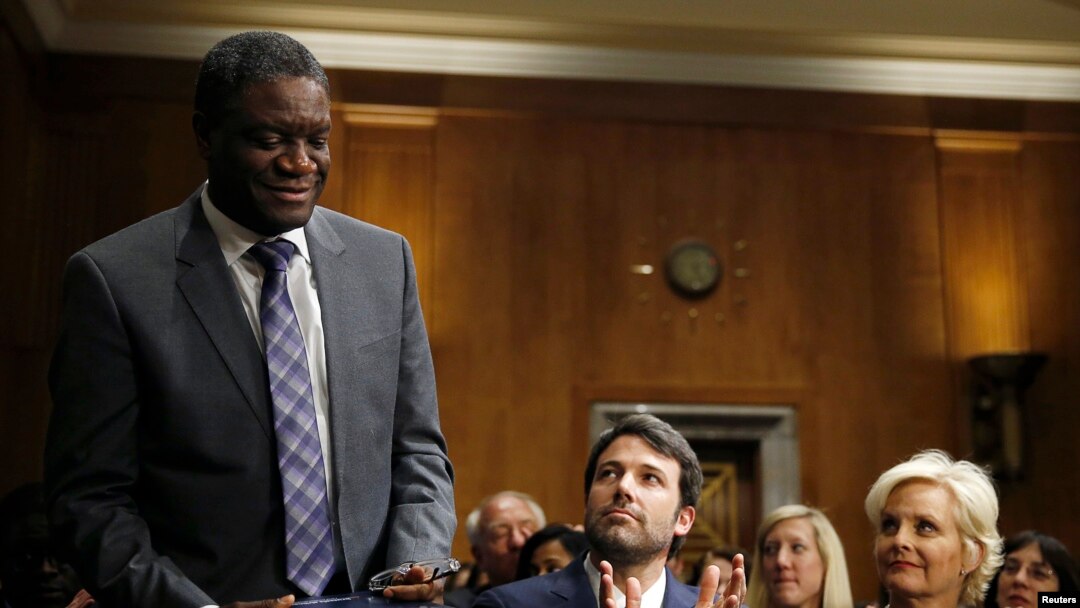Actor, writer and director Ben Affleck, center, and Cindy McCain, right, applaud Denis Mukwege, left, Medical Director of the Panzi Hospital in the Congo, at the Senate Foreign Relations Committee, Capitol Hill, Washington, Feb. 26, 2014.