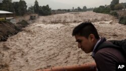 A man looks at the flow of the Huaycoloro river in Lima, Peru, March 16, 2017.