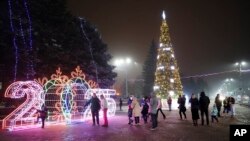 La gente camina en una plaza decorada para las festividades de Navidad y Año Nuevo en Donetsk, en la región de Donetsk controlada por Rusia, en el este de Ucrania, el 31 de diciembre de 2024.