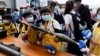 香港小学生在2021年4月15日的“全民国家安全教育日”展览上拿起仿造的榴弹发射器